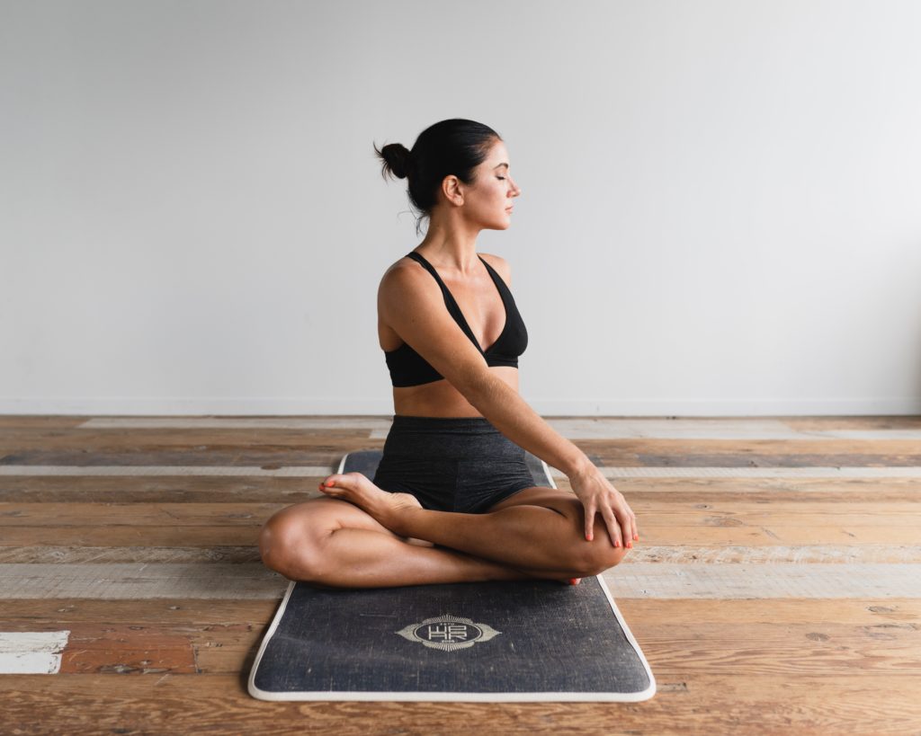 seated woman stretching on yoga mat