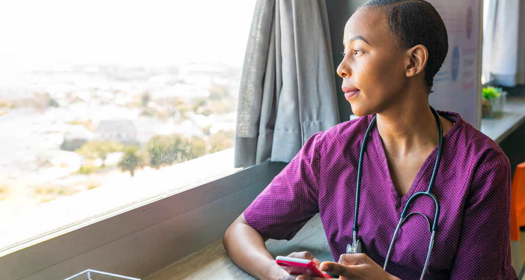 healthcare worker taking a mindful moment looking out window