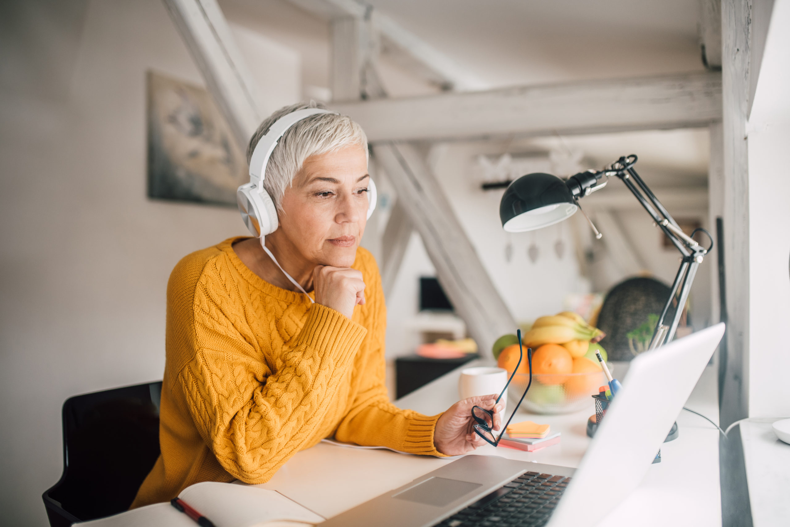 Woman working from home with headphones on.