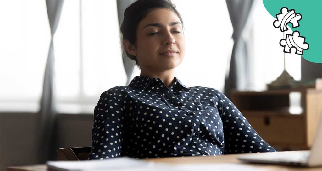 woman relaxing at desk with eyes closed